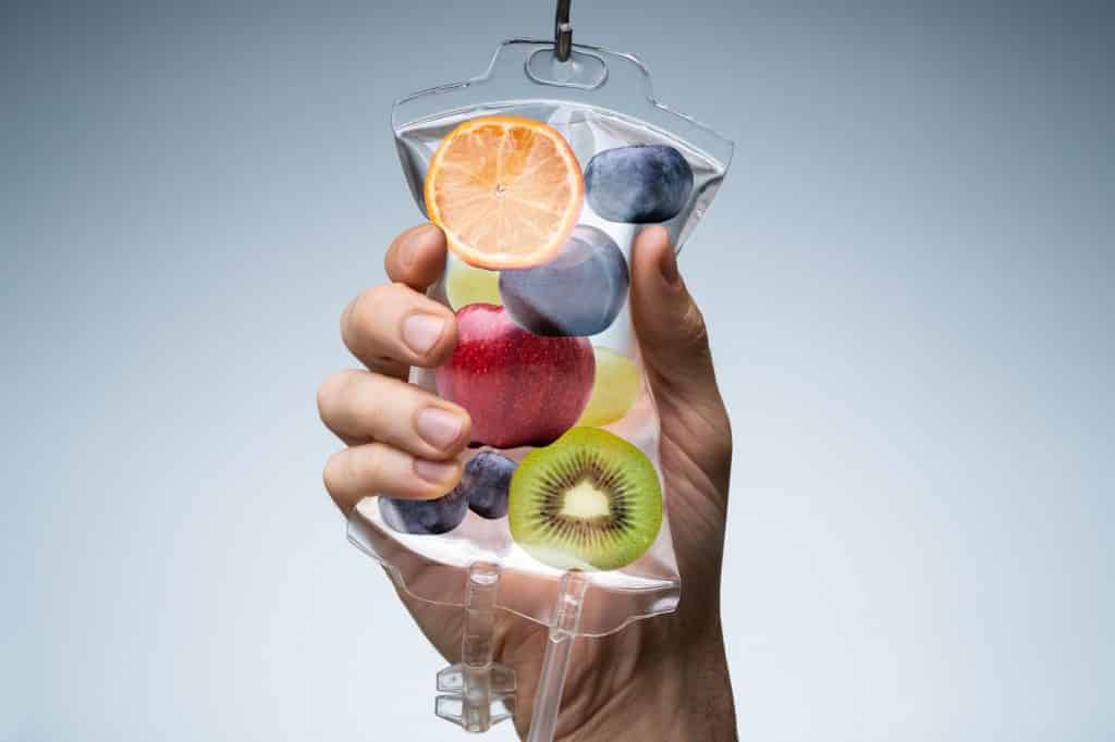 Person's Hand Holding Saline Bag Filled With Various Fruit Slices | Vibe Aesthetics in Hood River, OR