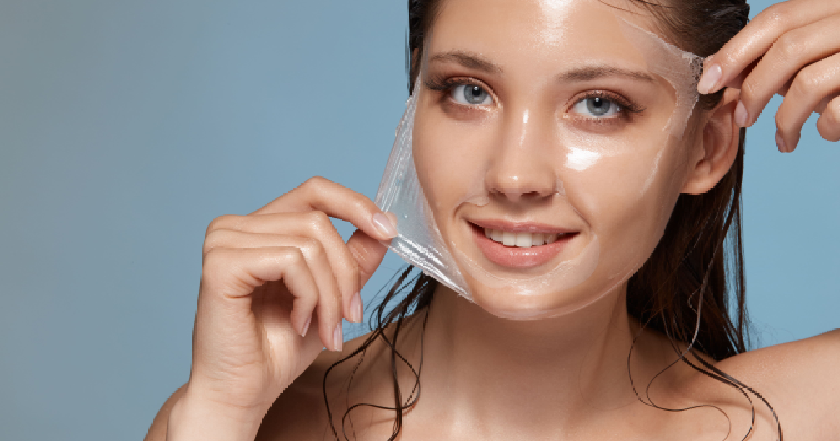 Woman smiling while removing a clear chemical peel mask, revealing smooth skin in Hood River, OR